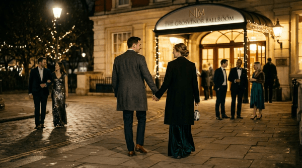 Couple holding hands walking toward The Grosvenor Ballroom entrance at night